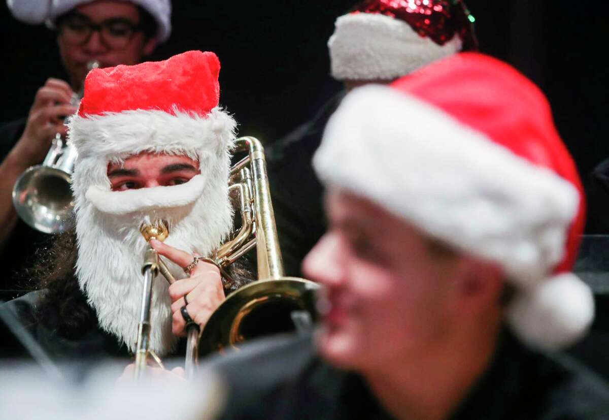 Conroe Jazz Connection trombonist Gunner Ramirez wears a Santa-themed beard and hat as he warms up before the group performs in downtown Conroe as part of the city’s Christmas tree lighting celebration, Tuesday, Nov. 29, 2022.
