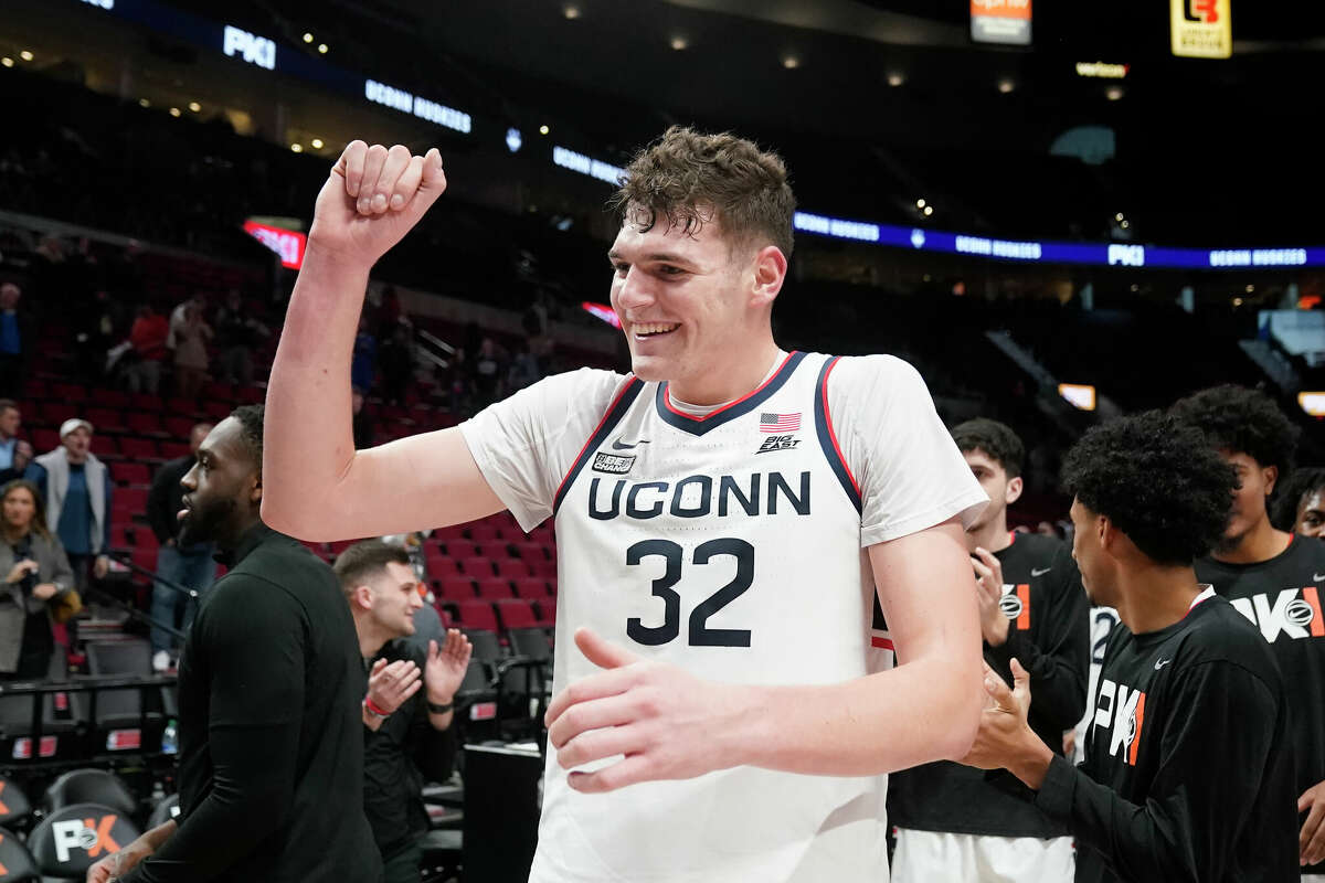Connecticut center Donovan Clingan (32) celebrates after winning the championship against Iowa State in the Phil Knight invitational Sunday, Nov. 27, 2022, in Portland, Ore. (AP Photo/Rick Bowmer)