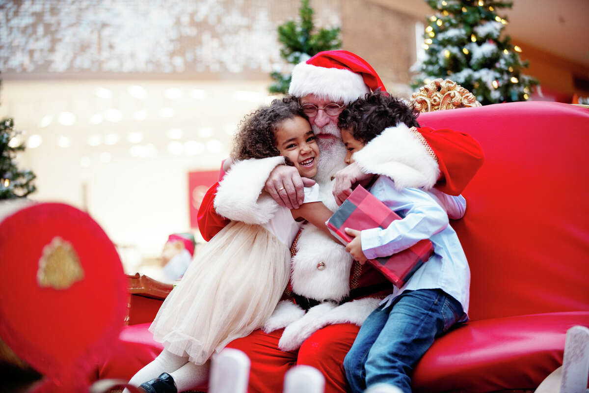 Santa hugging two children