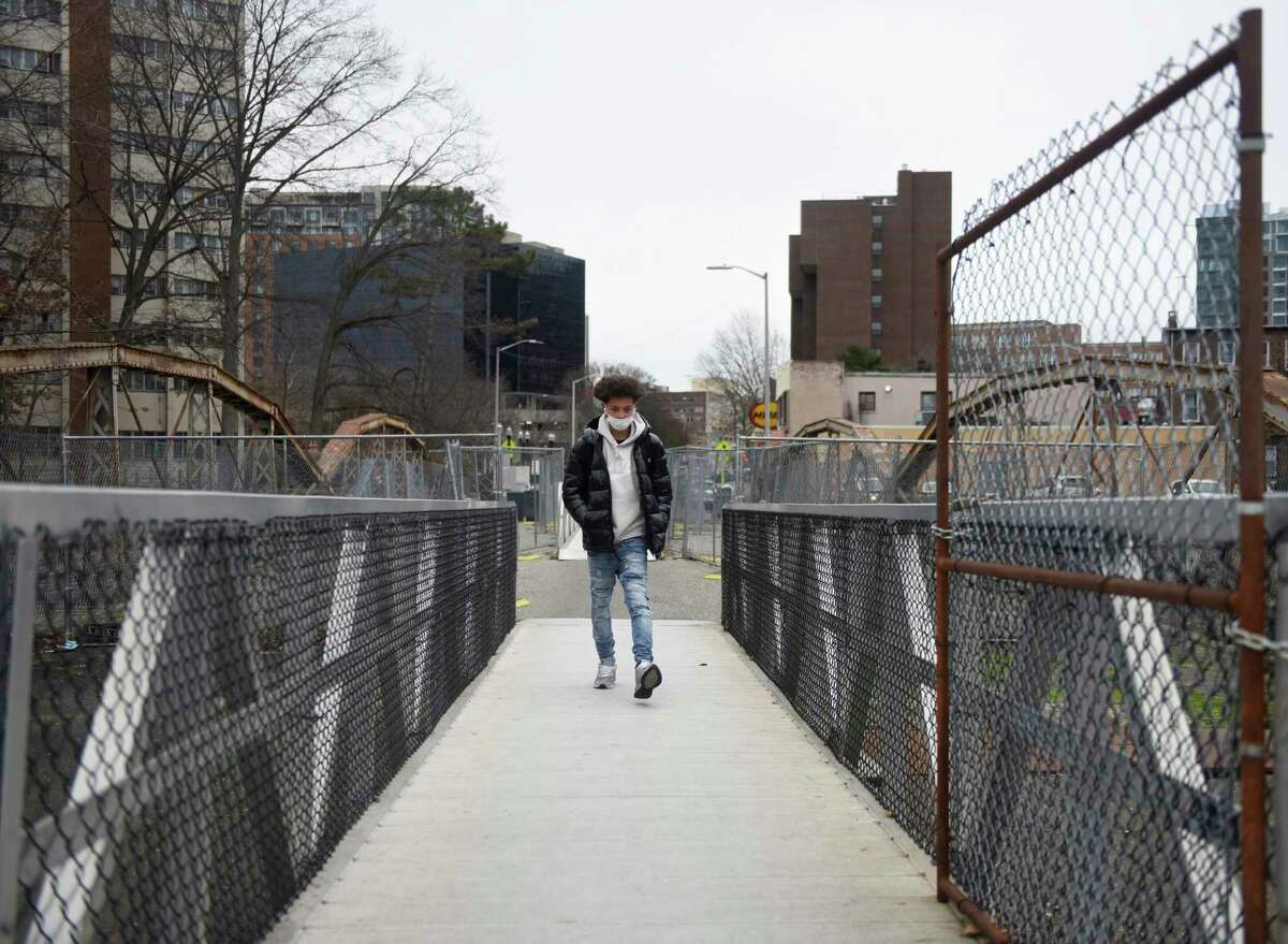 A pedestrian walks across the West Main Street Bridge in Stamford, Conn. Monday, Jan. 3, 2022. The Board of Representatives will vote Monday on an ordinance that urges the mayor to restore the West Main Street Bridge with vehicular traffic.