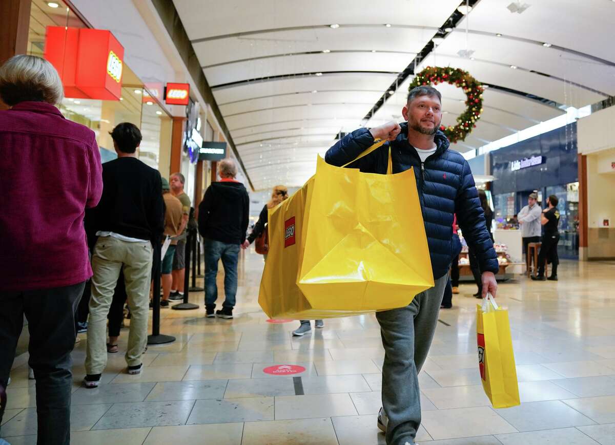 Cliff Gabriel walks through North Star Mall with his Lego Eifel Tower package after shopping during Black Friday.