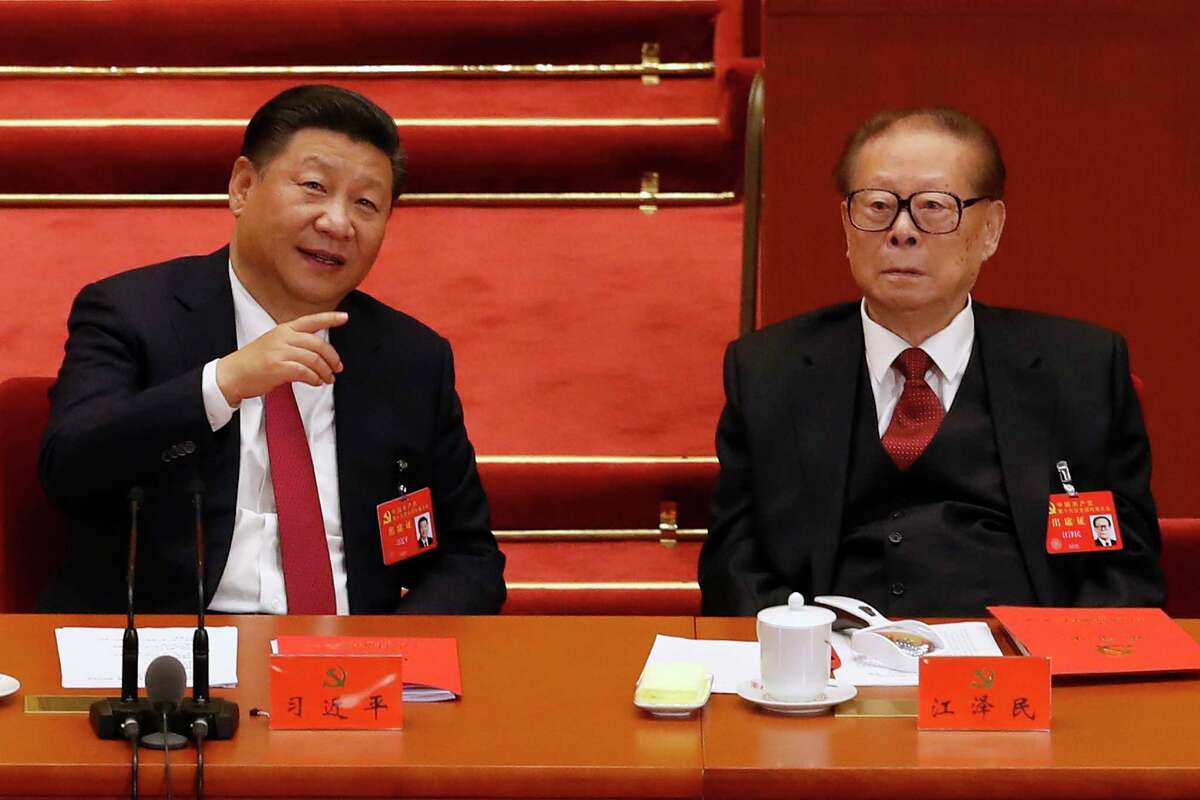 FILE - Chinese President Xi Jinping, left, chats with former President Jiang Zemin during the closing ceremony for the 19th Party Congress at the Great Hall of the People in Beijing, on Oct. 24, 2017. With his death, Jiang leaves behind a very different China than the one he tried to shape. Now it’s Xi Jinping’s nation.