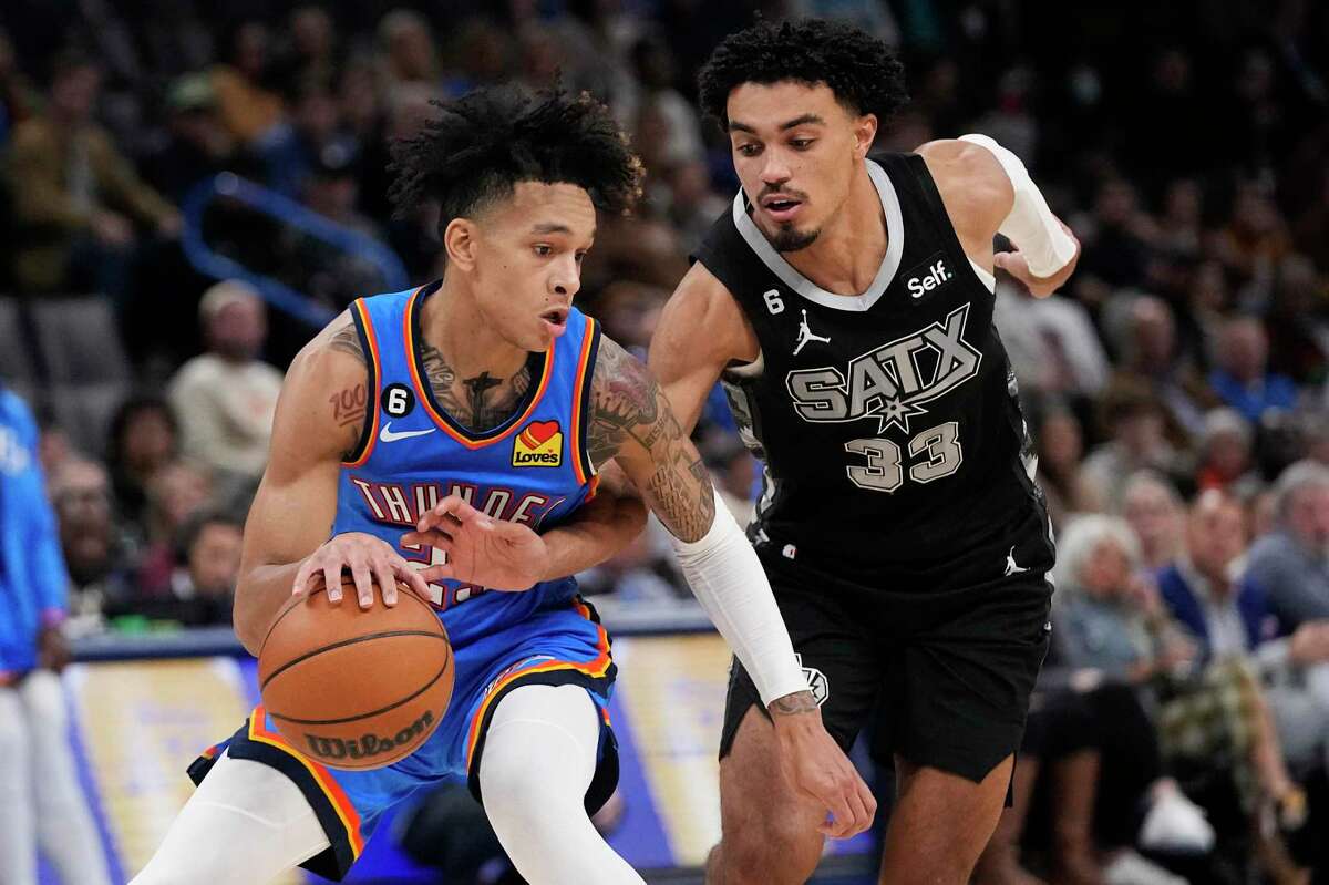 Spurs guard Tre Jones attempts to knock the ball away from Oklahoma City Thunder guard Tre Mann during the second half of Wednesday’s game in Oklahoma City.