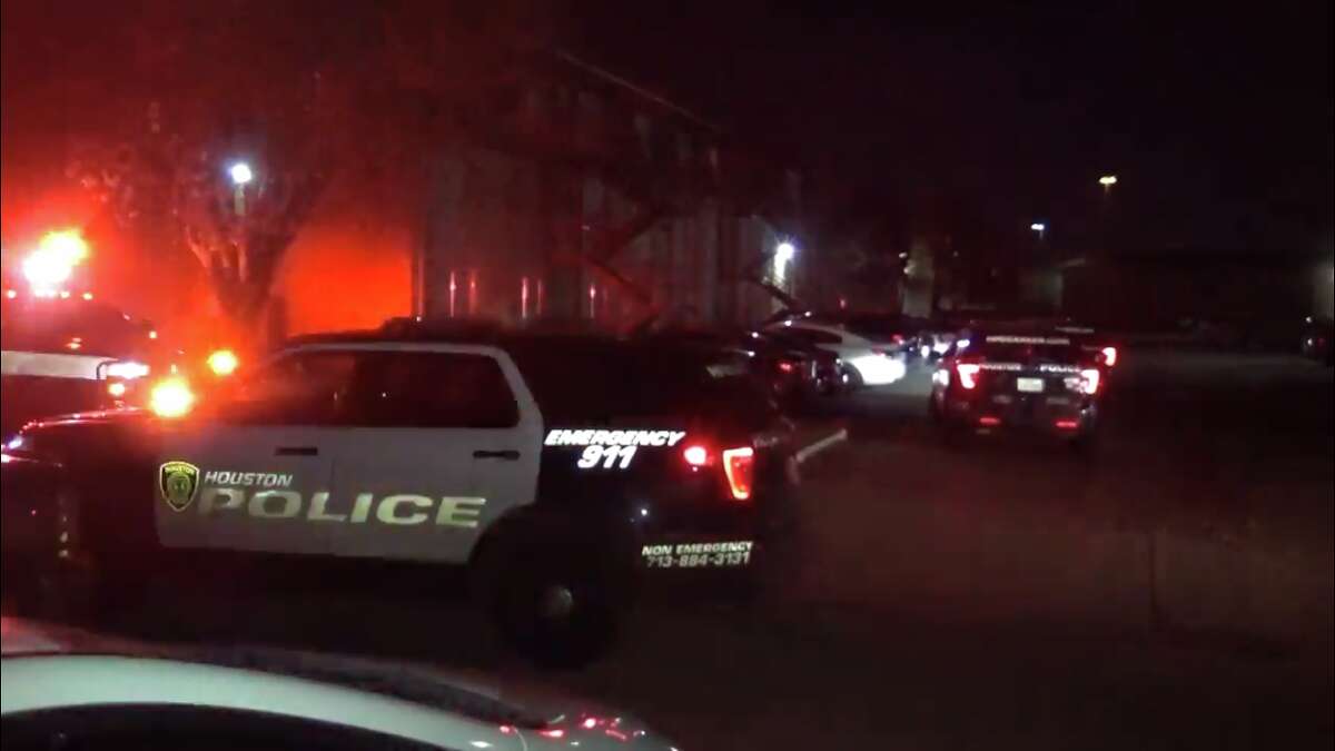 Police cars wait outside the scene of a fatal shooting in southeast Houston.
