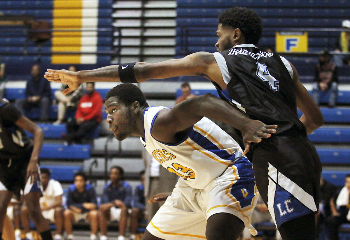 Michael Osei-Bonsu of Vincennes , left, tries to fend off  LCCC's NaVuan Peterson as they batle for position during Wednesday's night's game at the Vincennes University P.E. Complex in Vincennes, Indiana.