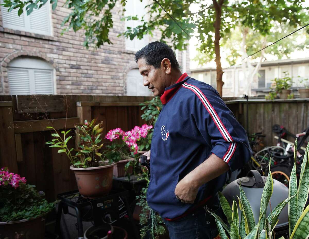 Antonio Gonzalez, 45, stands in his first-floor Gulfton apartment on Wednesday, Nov. 30, 2022 in Houston. His garden includes a wild mulberry tree, ruta (common rue), and mother-in-law tongue.