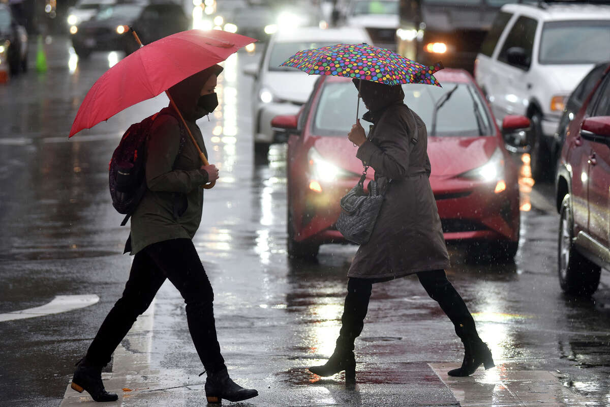 Pedestrians walk near Union Square in downtown San Francisco during heavy rain on Thursday, Dec. 1, 2022.