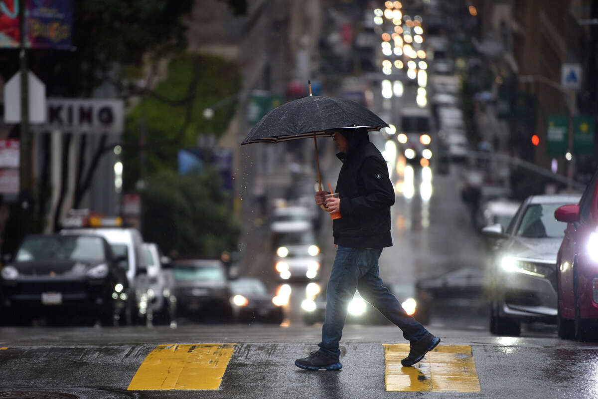 A pedestrian walks with an umbrella in downtown San Francisco during heavy rain on Thursday morning, Dec. 1, 2022. 