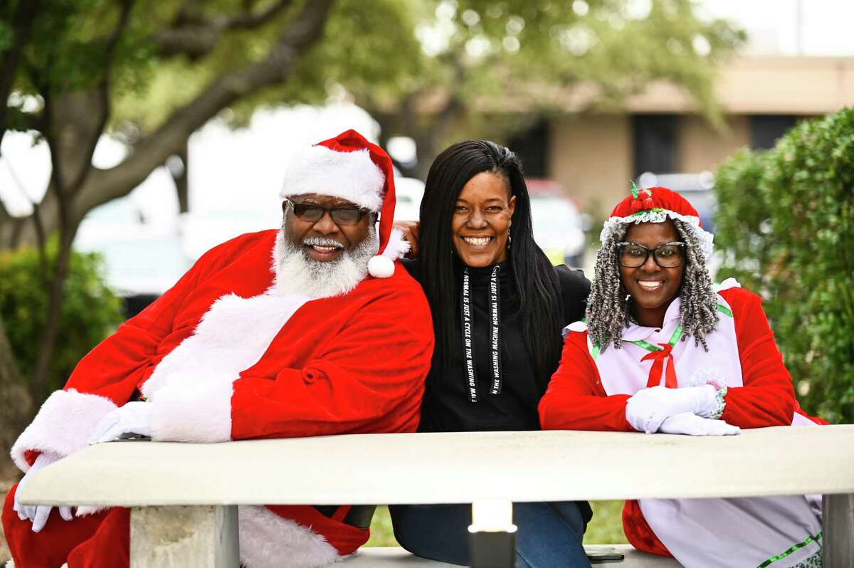 Nneka Cleaver poses for a portrait with Mr. and Mrs. Claus on Thursday.