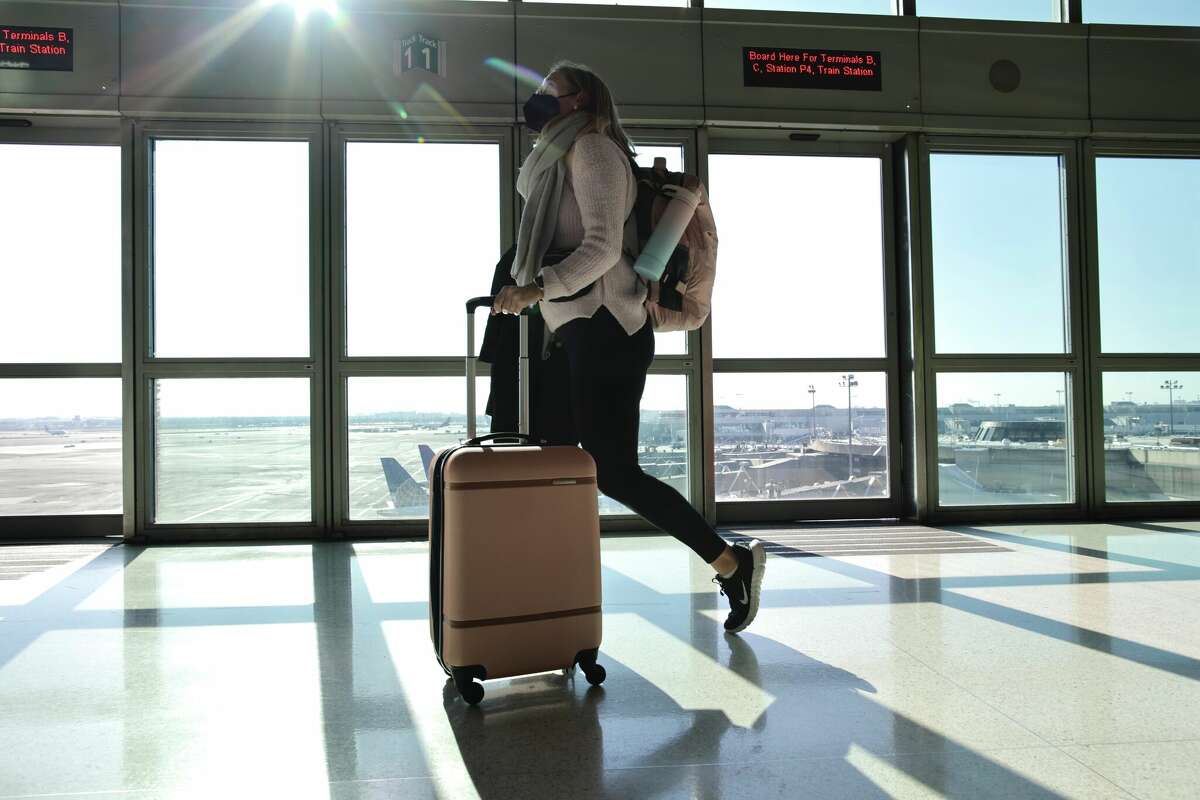 A passenger carries a bag at the Newark Liberty International Airport on Nov. 23, 2022, in New Jersey.