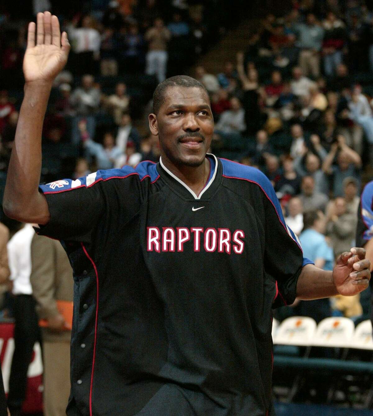Toronto Raptor Hakeem Olajuwon waves to the crowed while as he recieves a standing ovation while being introduced before the NBA game against the Houston Rockets at the Compaq Center 05 March 2002 in Houston, Texas. AFP PHOTO/James NIELSEN (Photo credit should read JAMES NIELSEN/AFP via Getty Images)