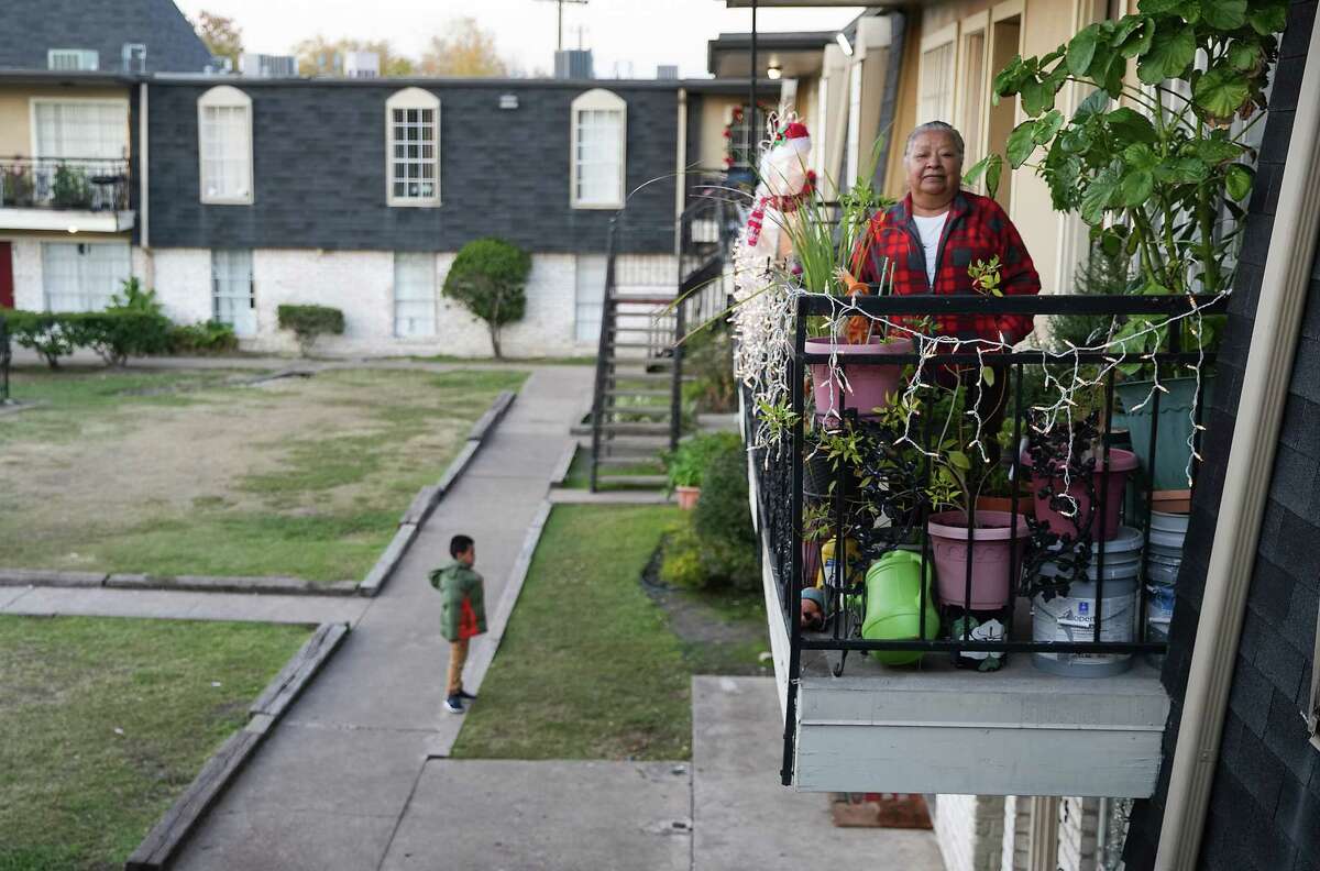 Juana Guerrero, 69, stands on her balcony with her plants outside her Gulfton apartment on Thursday, Dec. 1, 2022 in Houston.