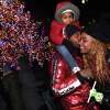 Jerome Clay of New Haven, carrying his son, Jeremiah Clay, 3, kisses his wife, Desiree Carter, at the Christmas tree lighting on the New Haven Green on December 1, 2022.