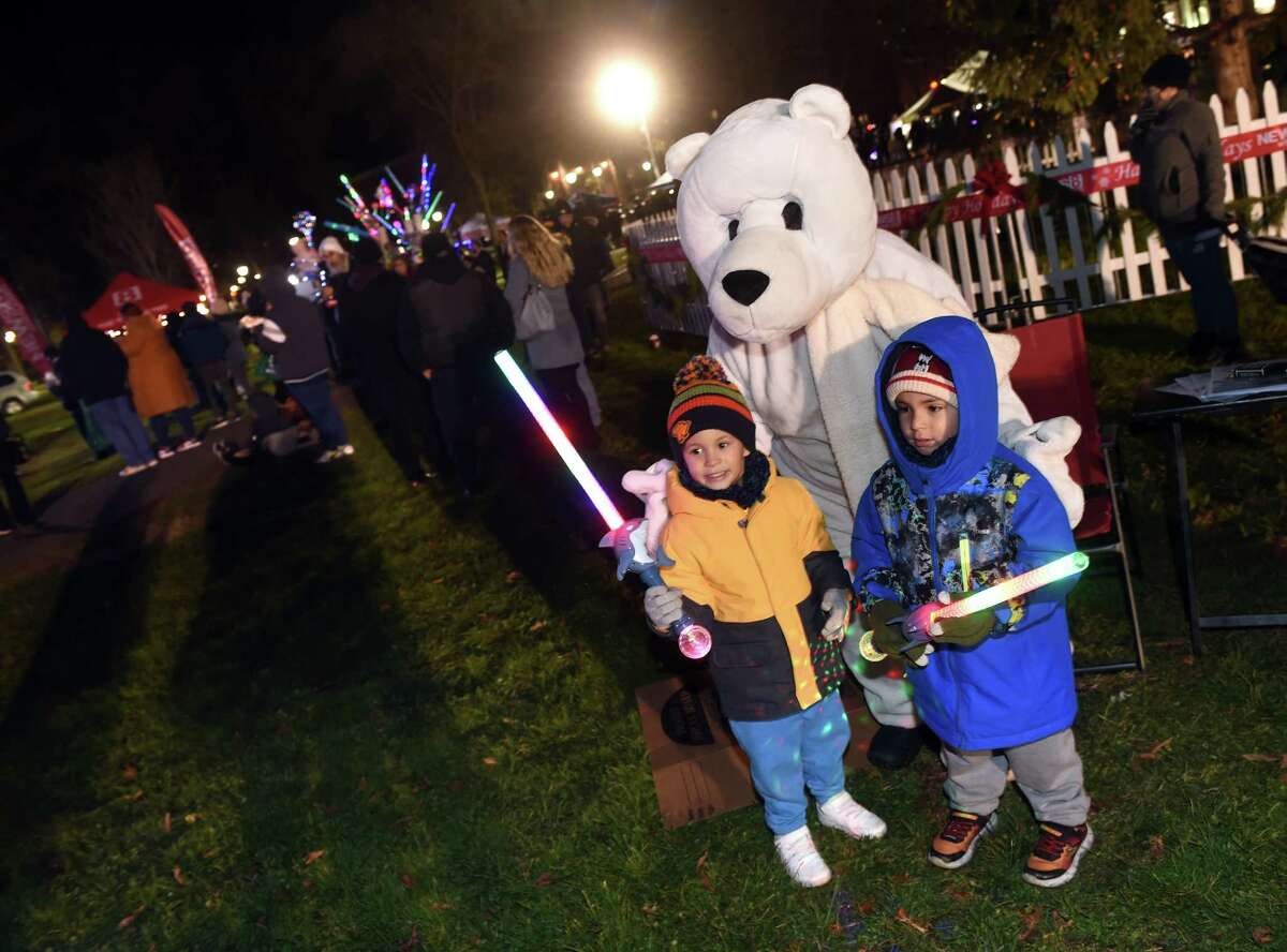 Angel Rodriguez, left, 3, and his cousin, Emiliano Ayala, 3, of New Haven pose with a polar bear at the Christmas tree lighting on the New Haven Green on December 1, 2022. The polar bear was promoting the Plunge for Parks on January 1, 2023 at Lighthouse Point Park in New Haven.