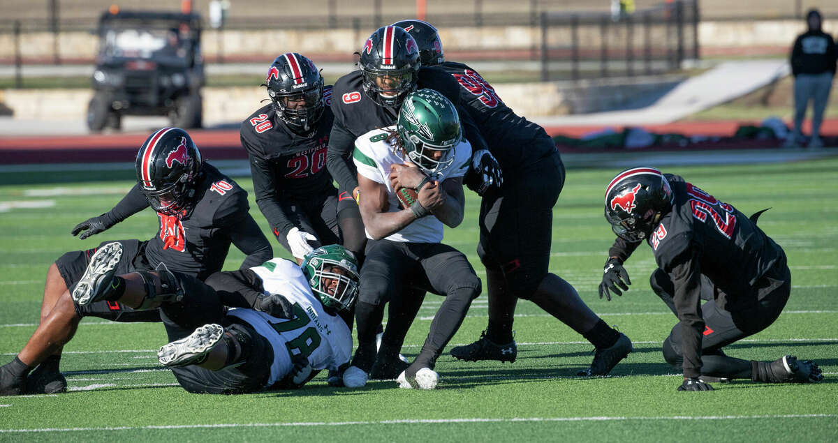 Waxahachie quarterback Ramon McKinney, Jr. is surrounded by a stiff Westfield defense including Christopher Walker (9) during the second half of a regional semi-final playoff in UIL 6A Division on November 26, 2022. Westfield won, 10-7 over Waxahachie to advance in next weeks' regional finals