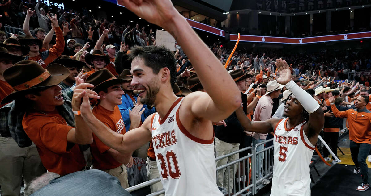 Texas forward Brock Cunningham (30) and guard Marcus Carr (5) celebrate with fans after the team's win over Creighton in an NCAA college basketball game in Austin, Texas, Thursday, Dec. 1, 2022. (AP Photo/Eric Gay)