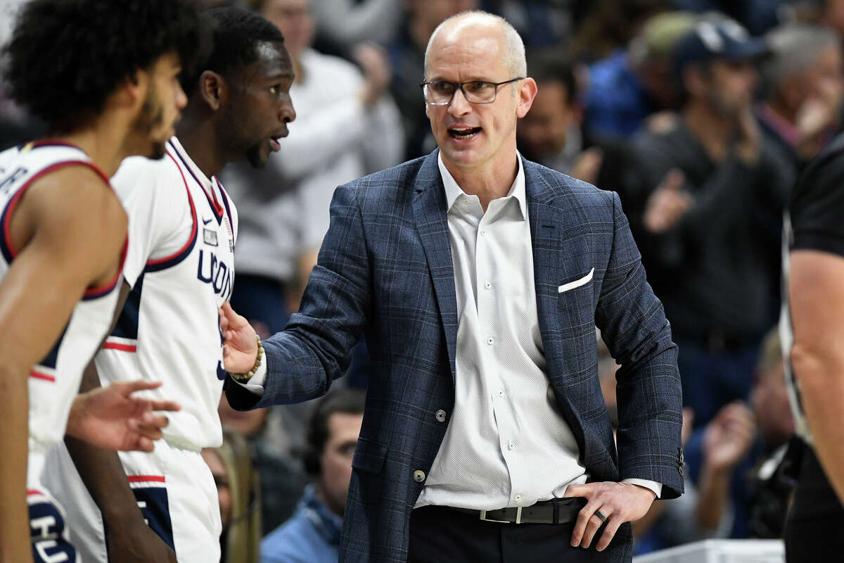 Connecticut head coach Dan Hurley, right, talks to Andre Jackson Jr., left, and Hassan Diarra, center, during a timeout in the first half of an NCAA college basketball game against Oklahoma State, Thursday, Dec. 1, 2022, in Storrs, Conn. (AP Photo/Jessica Hill)