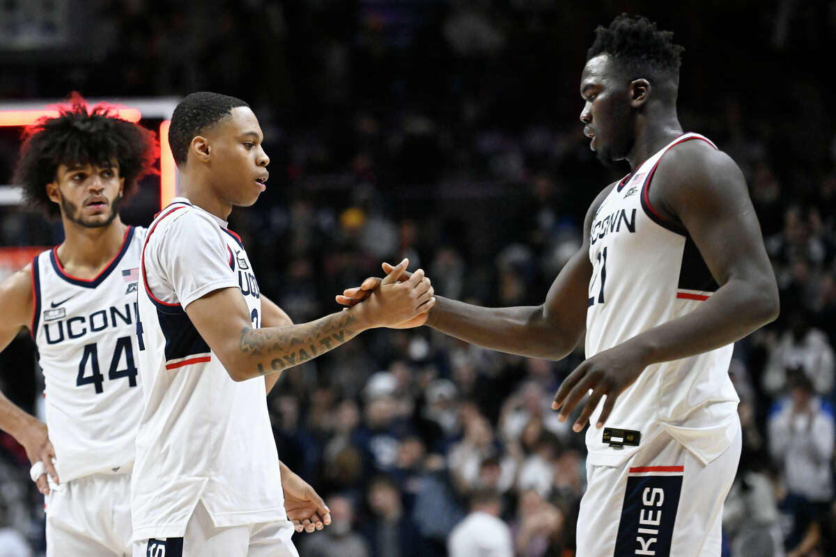Connecticut's Jordan Hawkins and Adama Sanogo shake hands at the end of an NCAA college basketball game against Oklahoma State, Thursday, Dec. 1, 2022, in Storrs, Conn. (AP Photo/Jessica Hill)