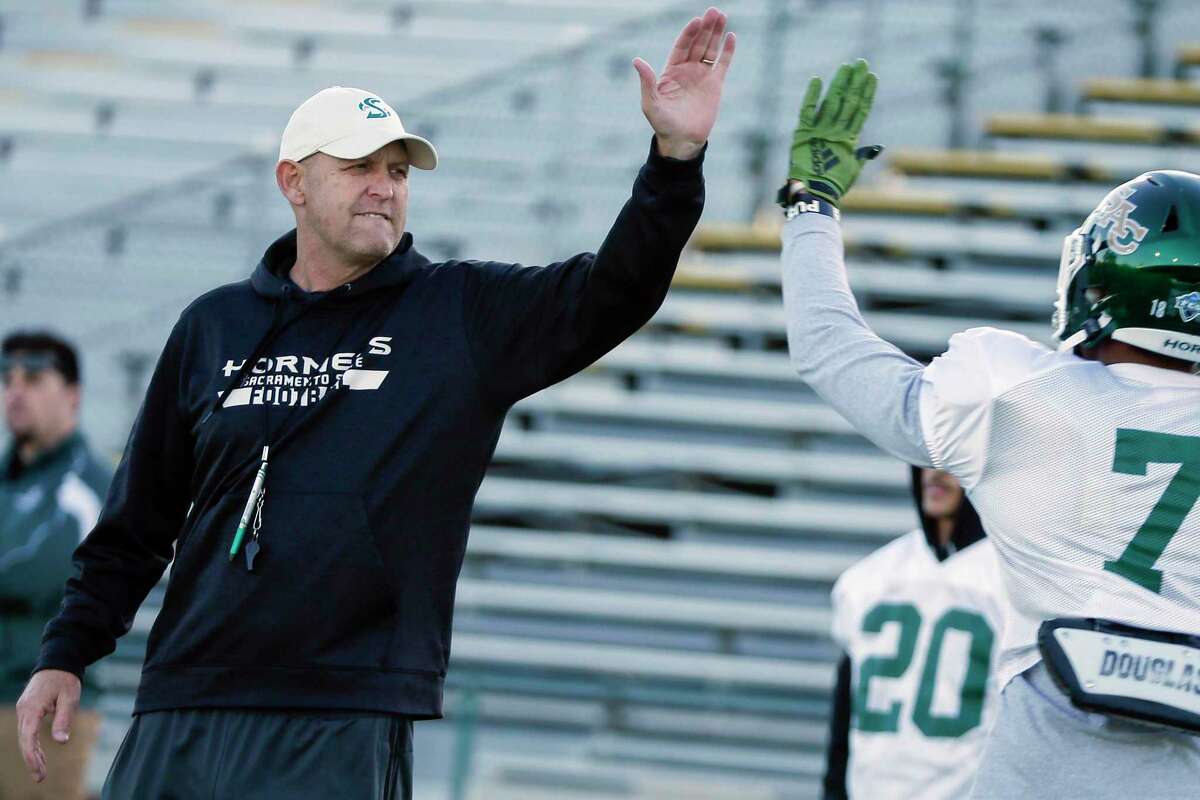 Sacramento State Hornets head coach Troy Taylor high fives players as they complete football drills at Hornet Stadium in Sacramento on Tuesday, Nov. 29, 2022.