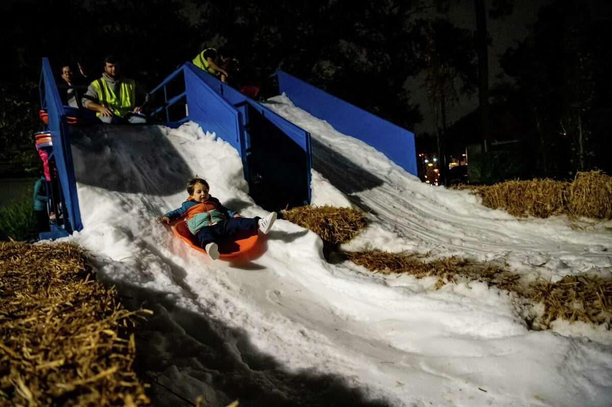 Three-year-old Jace Ivison plays on a snow slide during The City of Bellaire’s ‘Holiday in the Park’ event on Thursday, December 1, 2022 in Houston, Texas.