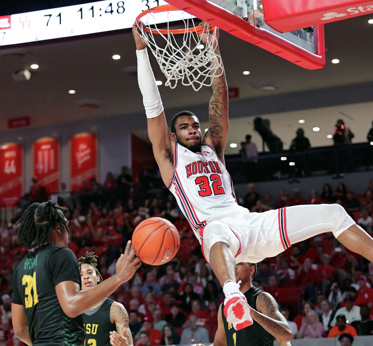 Reggie Chaney #32 of the Houston Cougars dunks over Cahiem Brown #31 of the Norfolk State Spartans during the second half at Fertitta Center on November 29, 2022 in Houston.