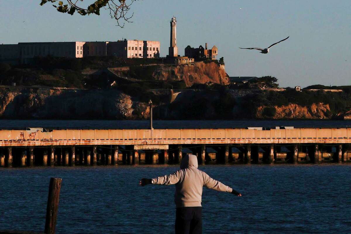 从旧金山的水上公园可以看到一个破旧的捕鱼码头，背景是恶魔岛。