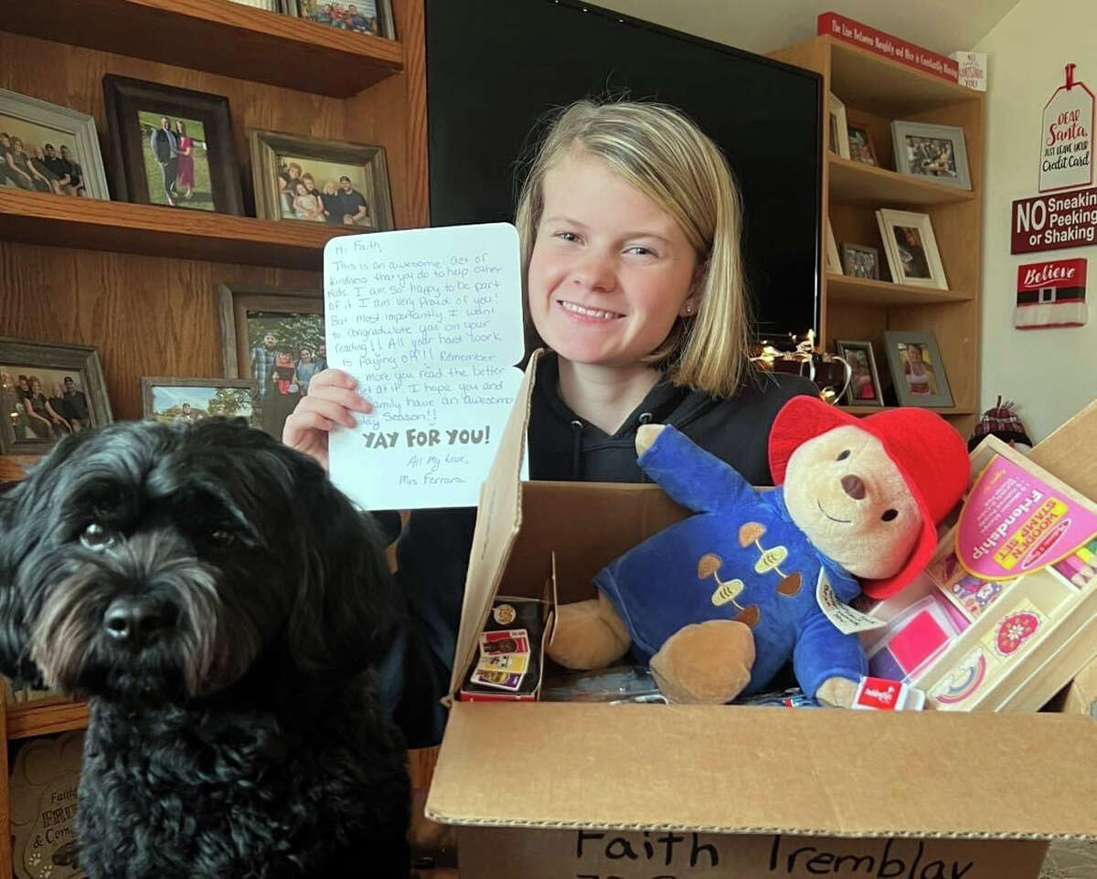 Faith Tremblay with her 4-year-old dog, Trooper, and some of the toys that she has collected for Faith's Holiday Toy Drive.