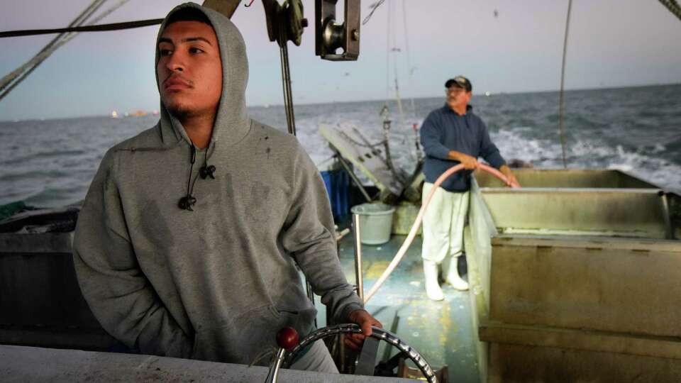 Adrian Gutierrez steers the boat as he and his father Alex prepare to fish for shrimp at sunrise Thursday, Oct. 27, 2022, in Galveston Bay. The pair fish for shrimp when oysters are not in season. 