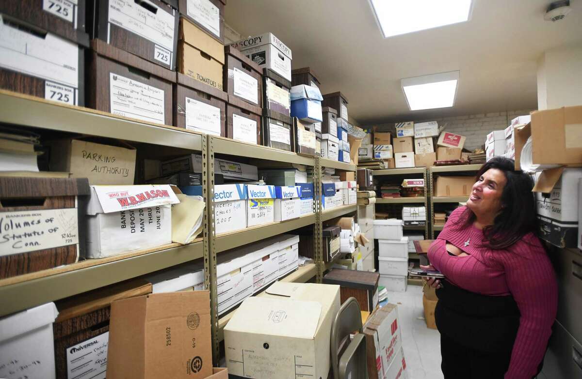 Ansonia Economic Development Director Sheila O'Malley with boxes of town records in a vault at City Hall in Ansonia, Conn. on Friday, December 2, 2022. The city has launched an initiative to digitize its records.