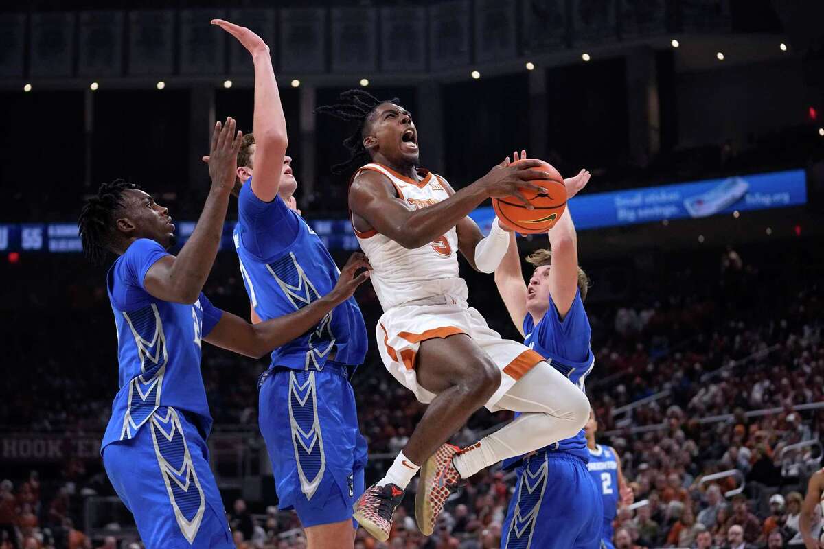 Texas guard Marcus Carr (5) drives to the basket past Creighton center Ryan Kalkbrenner, second from left, during the second half of an NCAA college basketball game in Austin, Texas, Thursday, Dec. 1, 2022. (AP Photo/Eric Gay)
