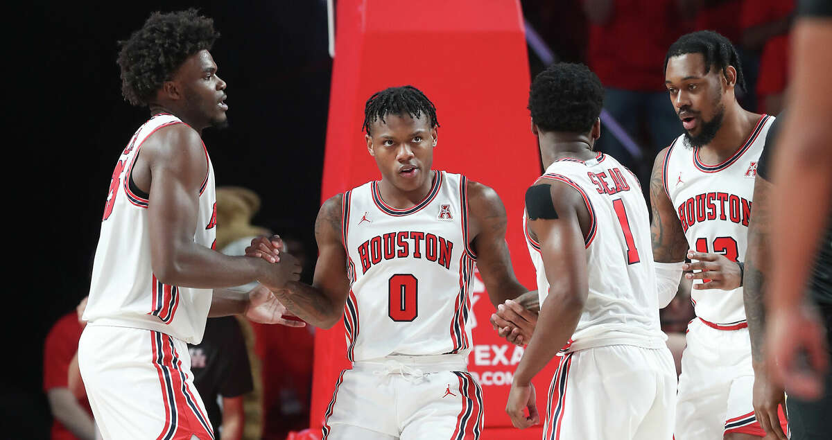 Houston Cougars guard Marcus Sasser (0) is assisted up by his team after drawing an offensive foul against Norfolk State Spartans at the Fertitta Center on Tuesday, Nov. 29, 2022 in Houston. Houston Cougars won the game 100-52