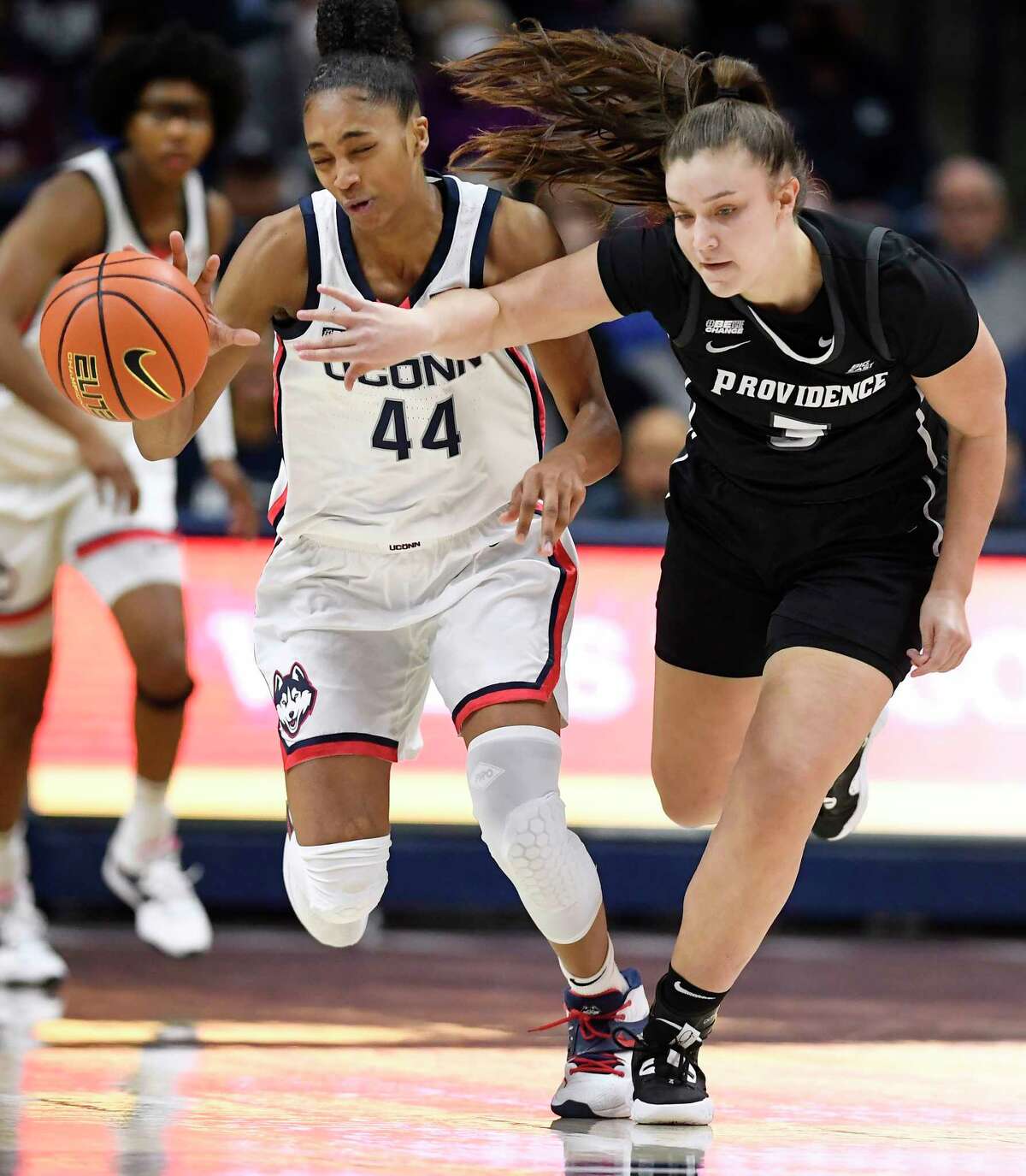 Connecticut's Aubrey Griffin (44) is fouled by Providence's Meghan Huerter (3) while stealing the ball in the first half of an NCAA college basketball game, Friday, Dec. 2, 2022, in Storrs, Conn.