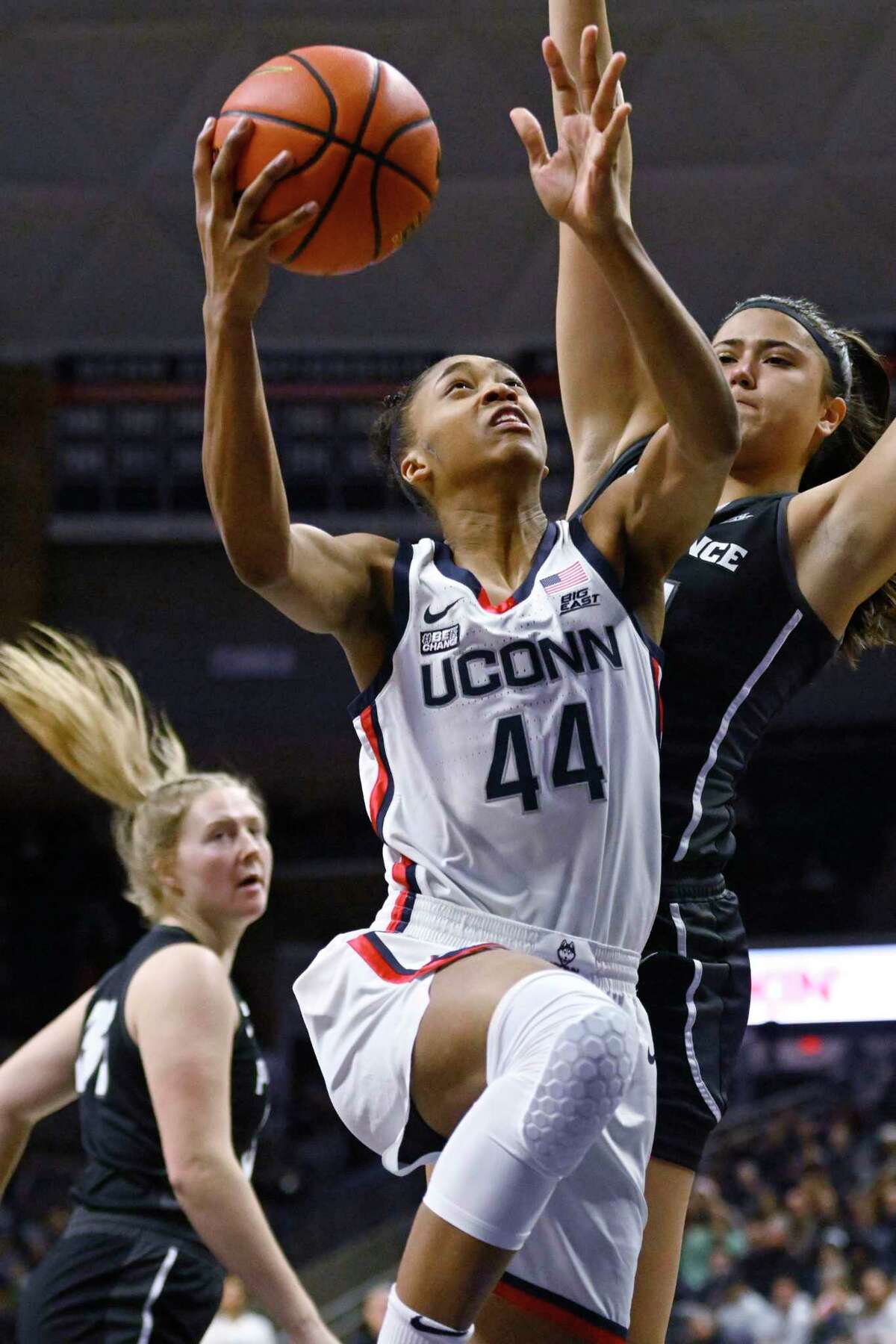 Connecticut's Aubrey Griffin (44) goes up for a basket as Providence's Olivia Olsen, right, defends in the first half of an NCAA college basketball game, Friday, Dec. 2, 2022, in Storrs, Conn.