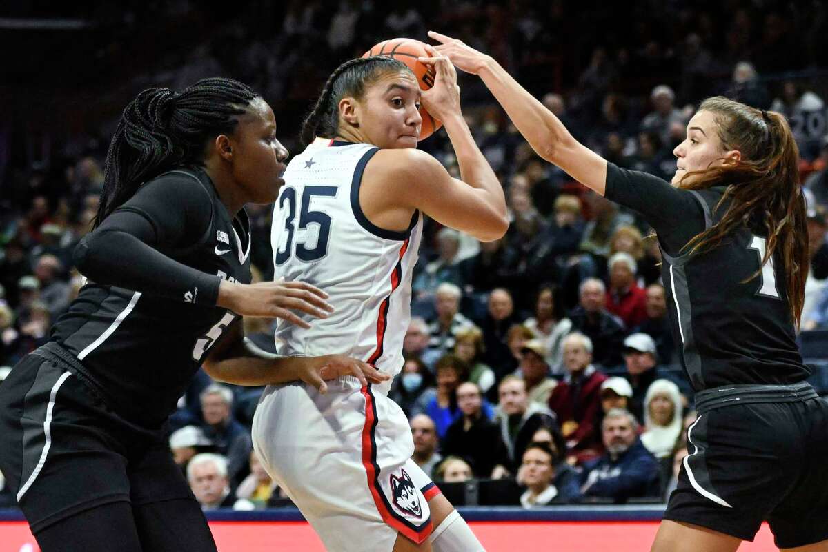 Connecticut's Azzi Fudd (35) is pressured by Providence's Janai Crooms, left, and Kylee Sheppard, right, in the first half of an NCAA college basketball game, Friday, Dec. 2, 2022, in Storrs, Conn.