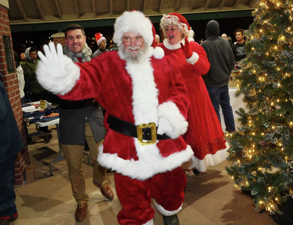Accompanied by Jimmy Tickey, left, Santa and Mrs. Claus arrive, waving to children, at the annual tree lighting at Veterans Park in Shelton, Conn. on Friday, Dec. 2, 2022.