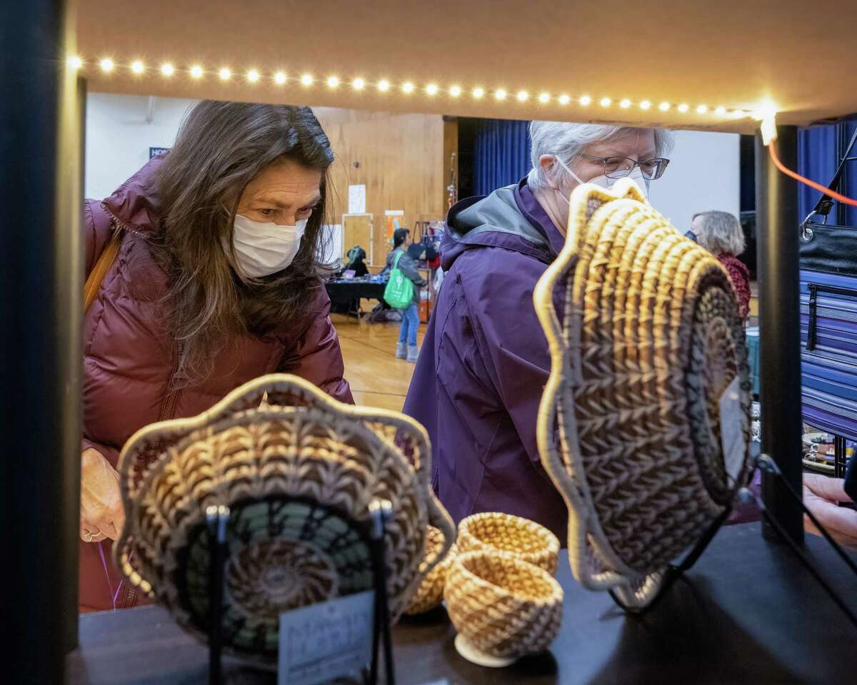 Gayle Vacca-Salada, left, and Beth Dorn look at merchandise on sale at the Mayan Hands booth during the St. Kateri Tekakwitha Parish free trade market featuring handmade crafts from around the world on Saturday, Dec. 3, 2022, in Schenectady, NY. It is the first time the market was held in person since 2019. (Jim Franco/Times Union)