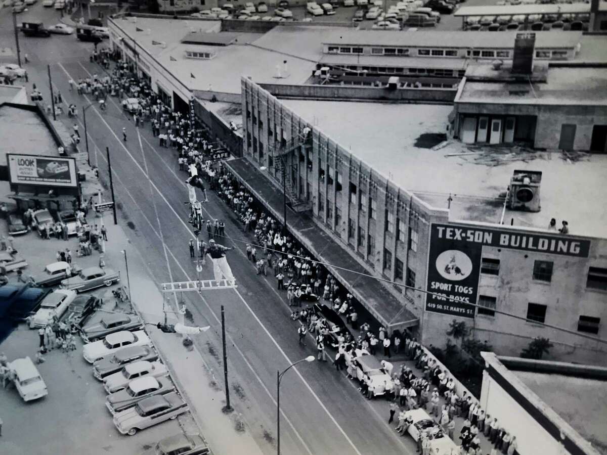 A photograph taken from the former Transit Tower (now Tower Life Building) shows members of the Zugspitzartisten Aerial Troupe performing April 20, 1955, near the corner of South St. Mary’s and Nueva streets. Promoting Fiesta San Antonio, they drew crowds to watch their high-wire feats.