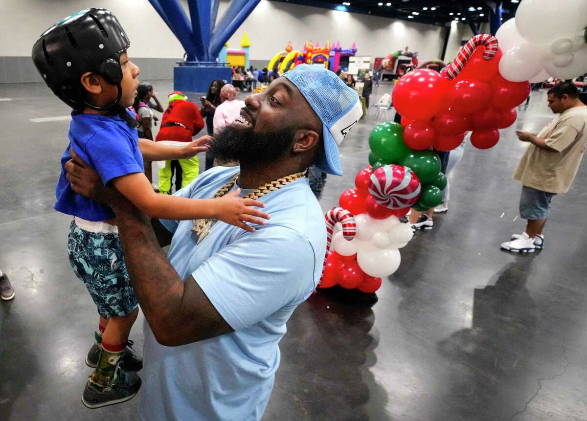 Trae tha Truth lifts Jordan Kemp up as he greets the four-year-old as he arrives to the inaugural City Wide “Special Needs” Day at the George R. Brown Convention Center on Saturday, Dec. 3, 2022 in Houston. More than 1,200 Houstonians participated in the event, organized by rapper and philanthropist Trae tha Truth, that featured games, music, face painting and rides for people of all ages.