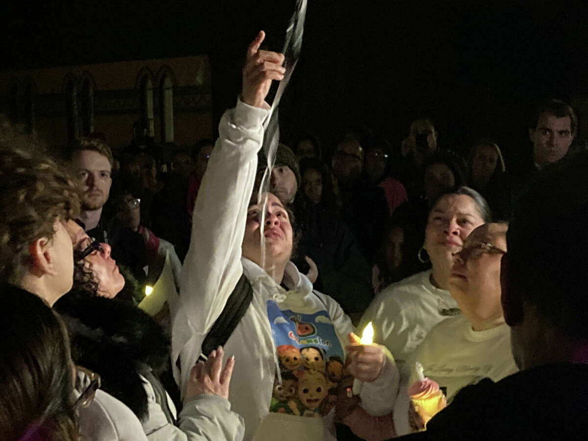 Camilla Francisquini's mother, Kristyl, releases a white balloon into the air at Saturday night’s vigil at the Naugatuck Green.