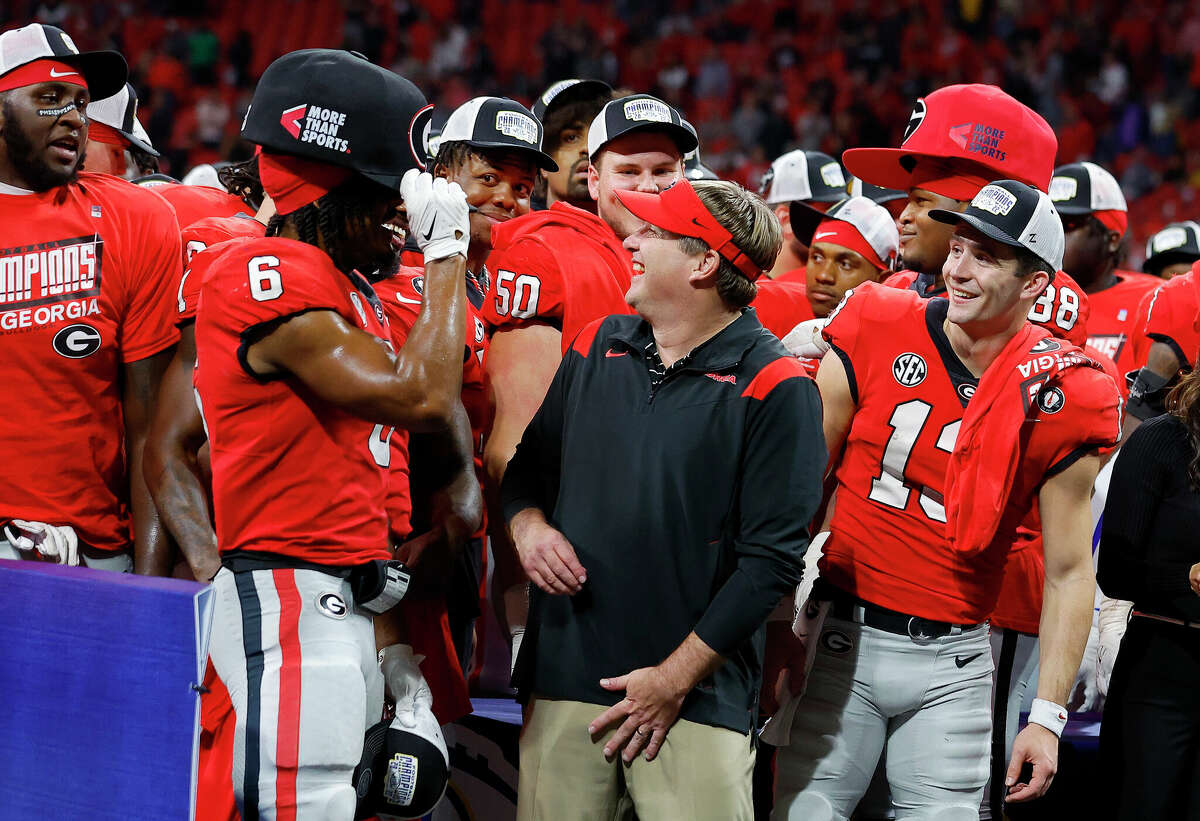 ATLANTA, GEORGIA - DECEMBER 03: (L-R) Kenny McIntosh #6, head coach Kirby Smart and Stetson Bennett #13 of the Georgia Bulldogs joke on stage after defeating the LSU Tigers in the SEC Championship game at Mercedes-Benz Stadium on December 03, 2022 in Atlanta, Georgia. (Photo by Todd Kirkland/Getty Images)
