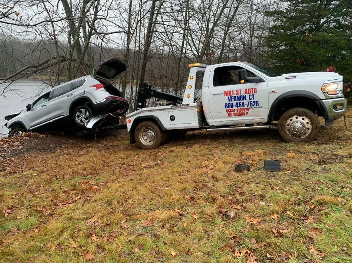 A tow truck hoists an SUV that was driven into Risley Reservoir on Saturday afternoon, Vernon police said.