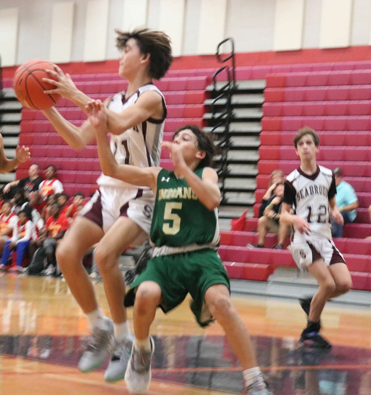 Seabrook Intermediate's Jordan Foret receives a pass against some tight Santa Fe defense at San Jacinto Intermediate School Friday night. Foret had 13 points, two assists during a second-half comeback. Looking on is Nicholas Groenueld.