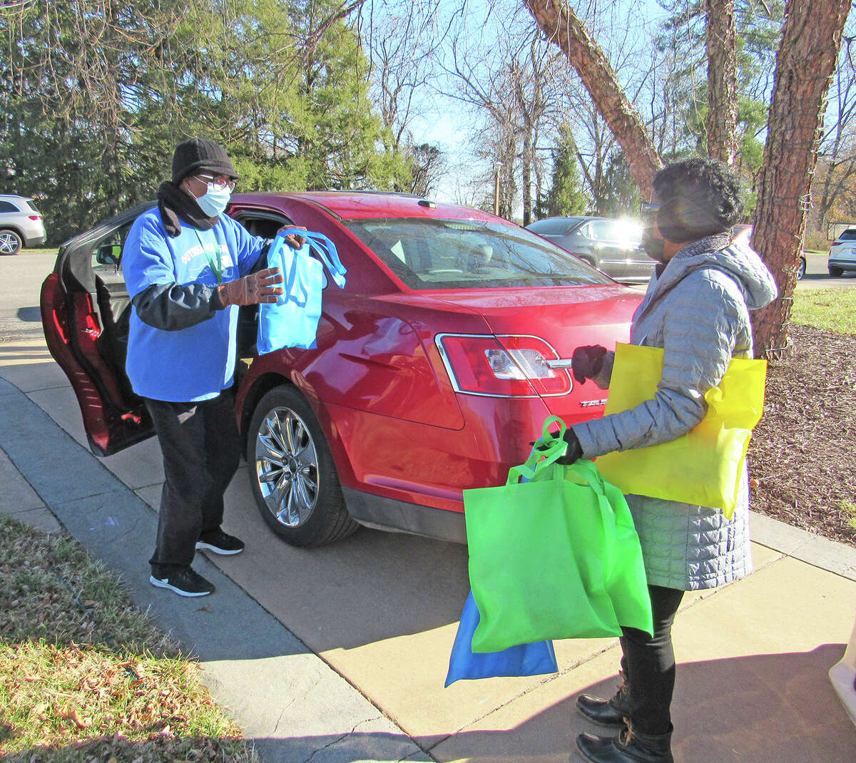 Metro Area Professional Association (MAPO) volunteers distribute items to recipients Saturday during the Metro Area Professional Association (MAPO) Holiday Shoutout Drive-By Giveaway at National Shrine of Our Lady of the Snows in Belleville.