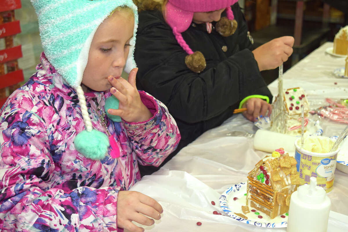 Jewel Filio-Woods, 7, daughter of Michael Woods and Jamie Filio, enjoys a bit of icing while she decorates a gingerbread house during the Christmas Around the Square in Virginia. More photos from weekend events are on myjournalcourier.com.