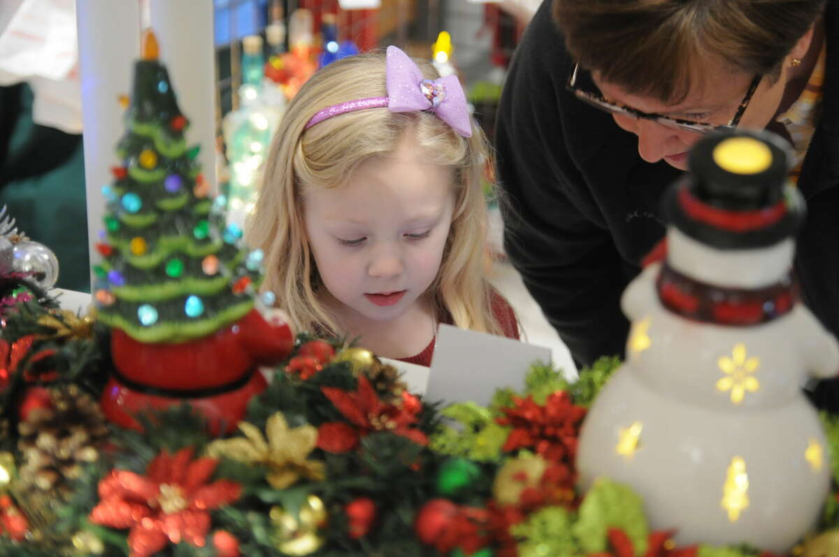 Four-year-old Lydia Seymour of Alton looks over holiday offerings during the Olde Alton Arts and Crafts Fair. More than 200 vendors participated in the holiday season highlight presented by the Alton Band and Orchestra Builders.