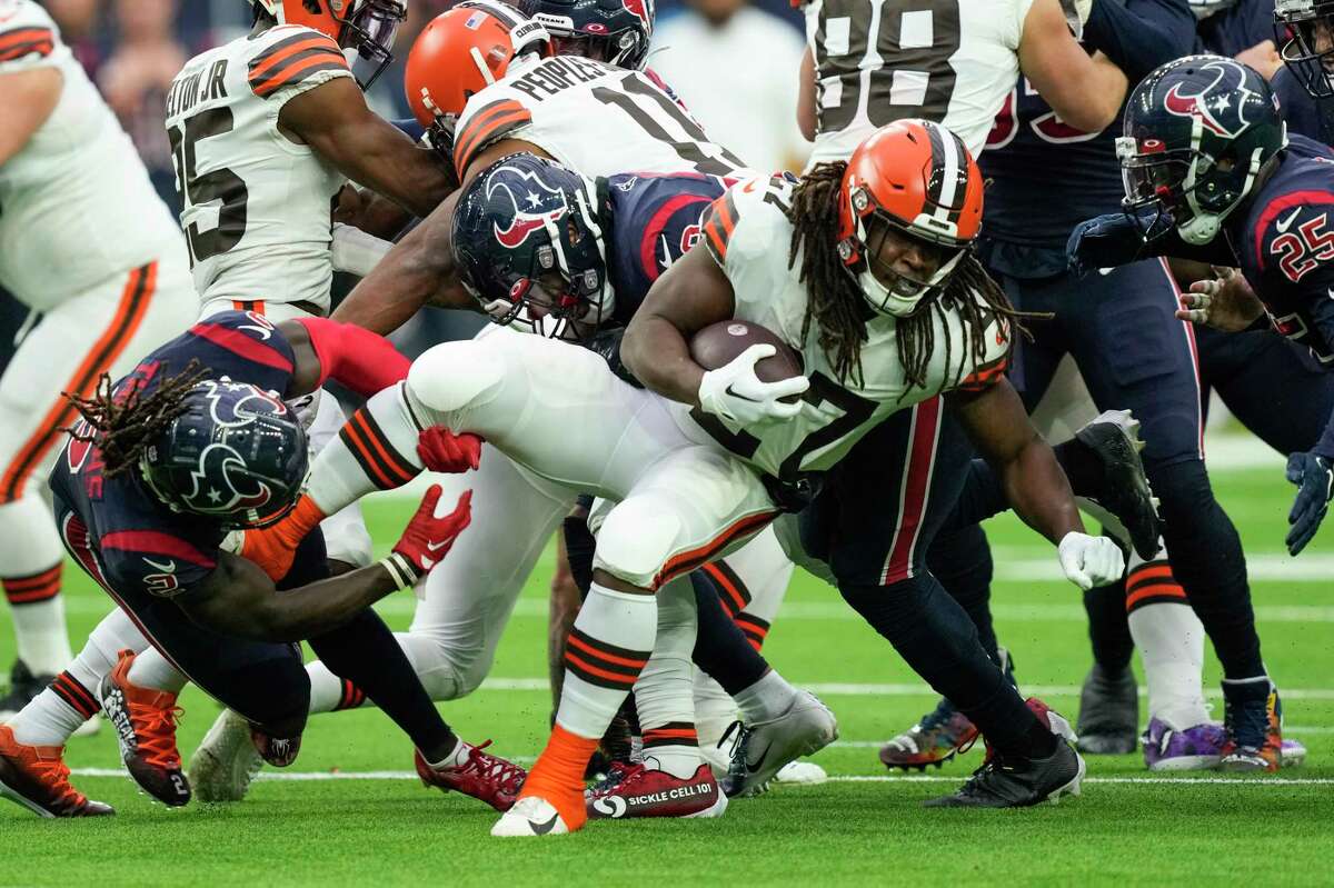 Cleveland Browns running back Kareem Hunt (27) is stopped by Houston Texans cornerback Tavierre Thomas (2) during the first half an NFL football game Sunday, Dec. 4, 2022, in Houston.