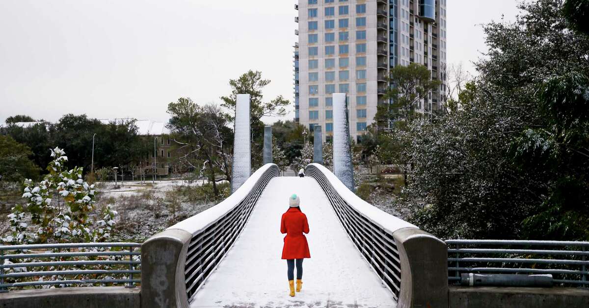 Olivia Park walks through the snow across the Jackson Hill Bridge in Buffalo Bayou Park Friday, Dec. 8, 2017 in Houston.