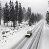 A truck traveled the winter roads throughout in Meyers, Calif., on Friday. More snow and wind has made Sunday travel difficult for drivers.