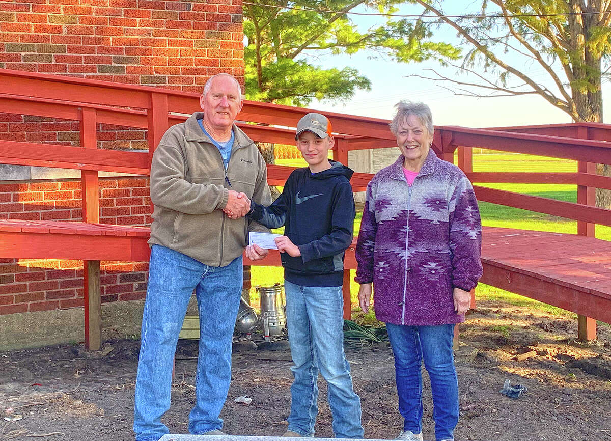 Jet Walker, treasurer of Berea Ag 4-H, and Berea Christian Church members Ron and Deb Petefish accept a check from Farm Credit Illinois. 