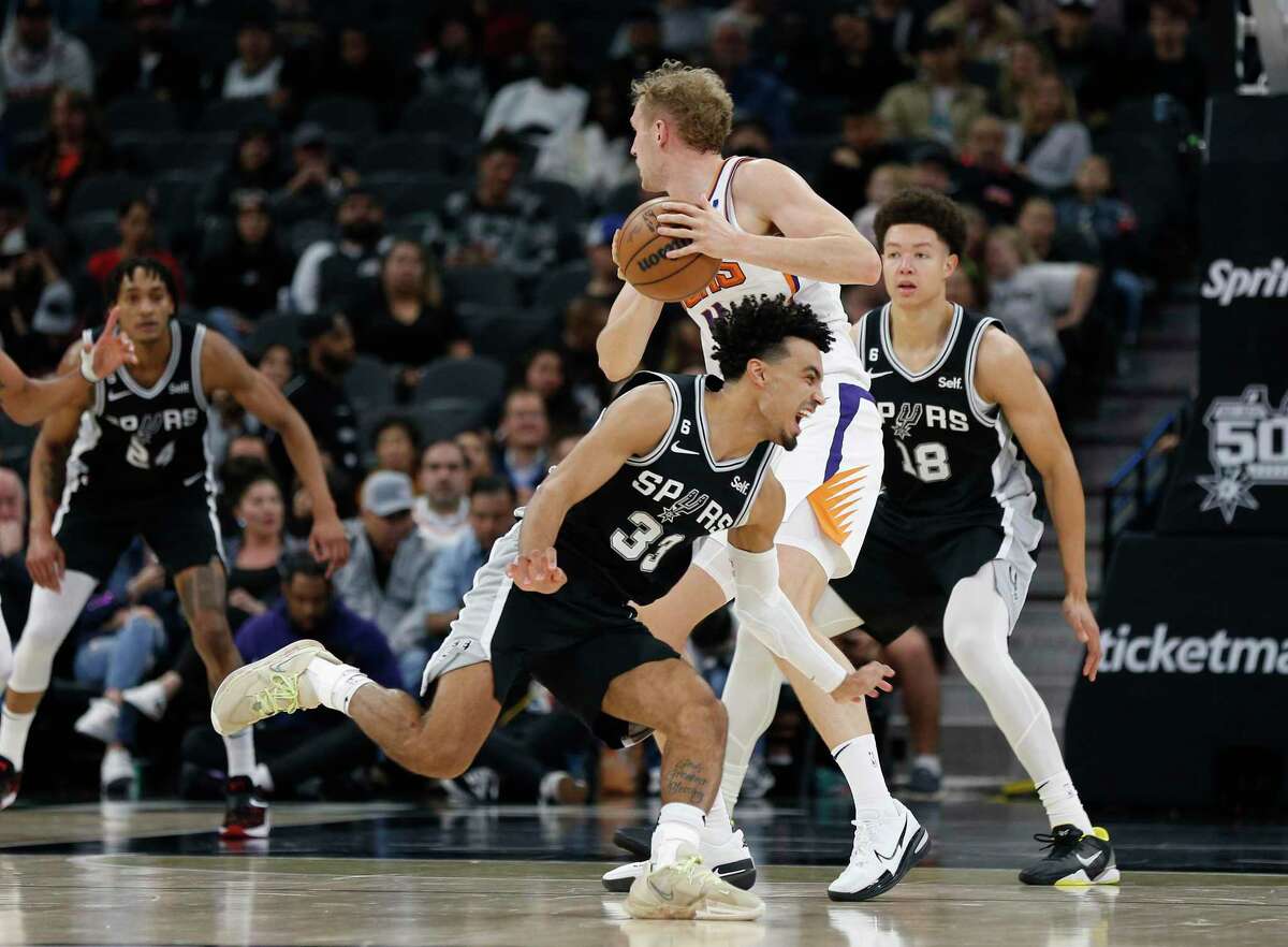 Tre Jones (33) of the Spurs tries to steal the ball from Jock Landale during the first half on Sunday’s game.